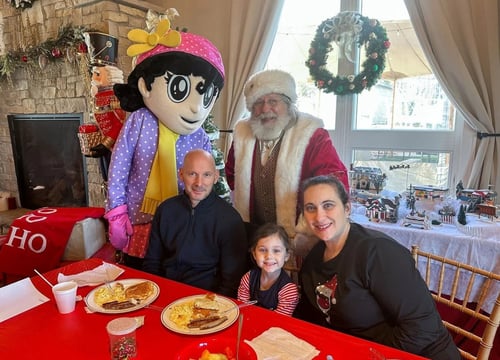 family enjoying pancakes & sausage at breakfast with santa event family enjoying pancakes & sausage at breakfast with santa event