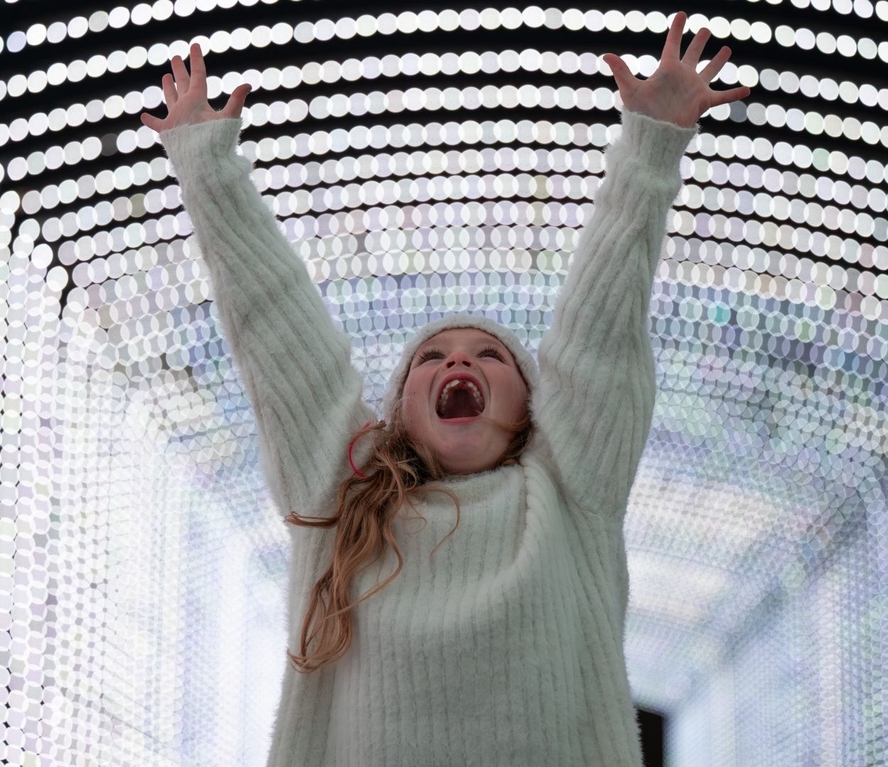 Girl smiling with joy because she is surrounded by dazzling lights at the Christmas Carnival of Lights Girl smiling with joy because she is surrounded by dazzling lights at the Christmas Carnival of Lights