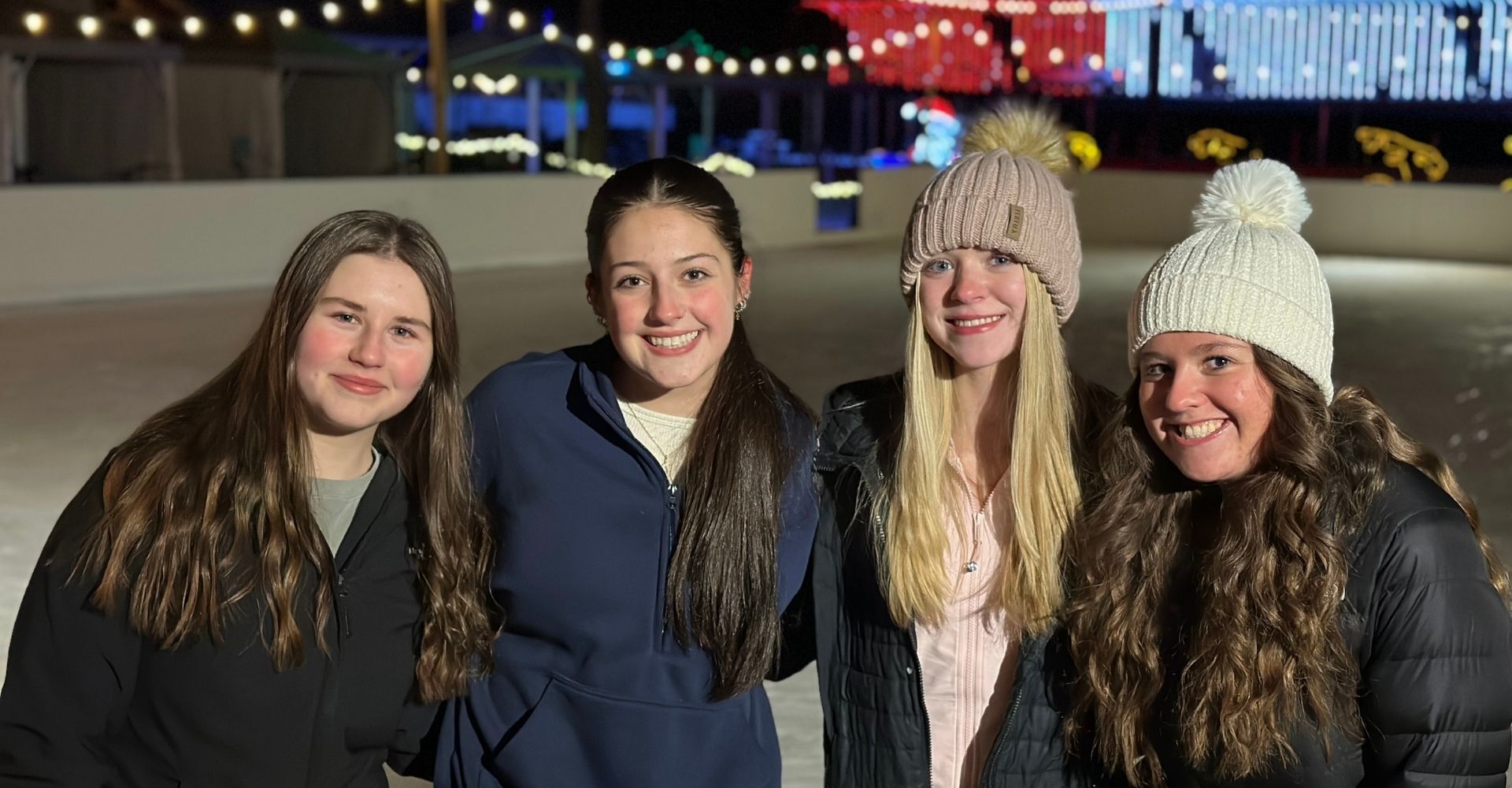 Girls skating under the lights on the outdoor ice skating rink at the Christmas Carnival of Lights Girls skating under the lights on the outdoor ice skating rink at the Christmas Carnival of Lights
